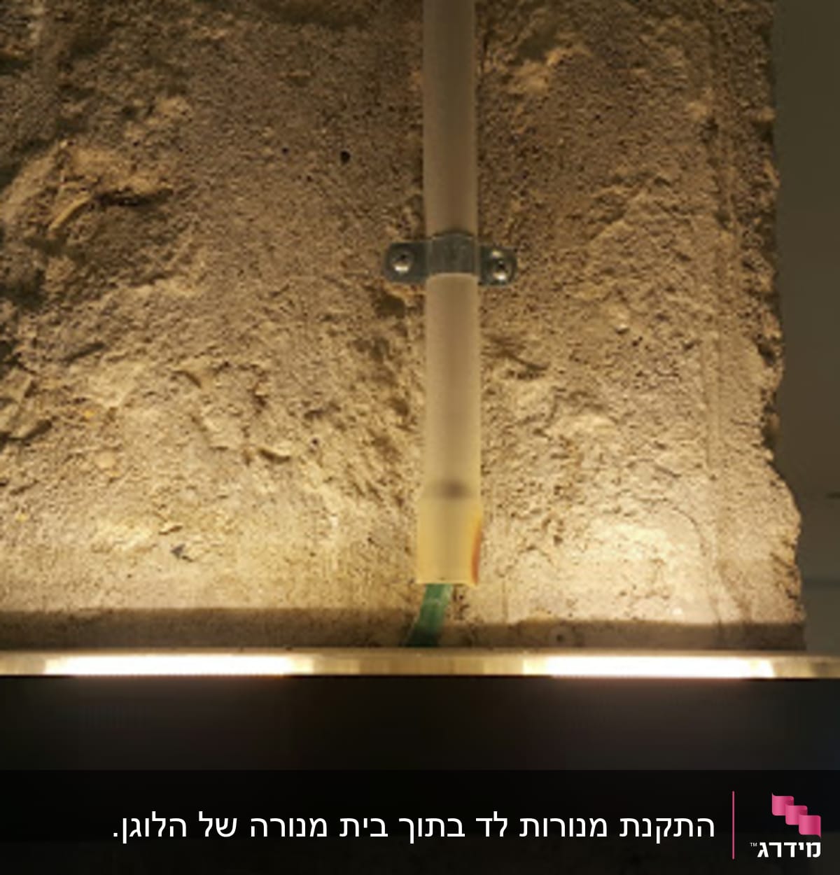 תאורה מותקנת על קיר בטון עם צינור חשמל